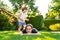 Happy siblings playing on green grass in garden backyard at sunset.