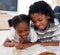 Happy siblings reading lying on the floor