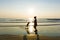 Happy single mom family silhouettes on beach