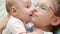 Happy sister kissing baby brother. Close up of girl kiss cute baby boy
