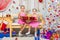 Happy sisters holding a big red gift and sit on a bench in a Christmas setting