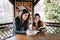 Happy sisters reading books in gazebo in park