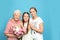 Happy sisters with their grandmother holding flowers