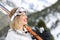 Happy skier holding skis looking at mountain