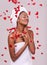 Happy, skincare and black woman with red petals, dermatology and treatment on a white studio background. Wellness