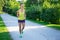 Happy slim jogging woman running in park