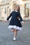 Happy small ballet dancer in school uniform balance on leg outdoors, ballerina