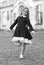 Happy small ballet dancer in school uniform balance on leg outdoors, ballerina