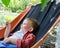 Happy small boy relaxing in a hammock