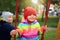 Happy Small children roll each other on swing. Children playing on the carousel. Children playground