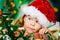 Happy small girl in Santa\'s hat has a Christmas