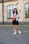 Happy small kid in school uniform hold books and toy dog in schoolyard, homework club