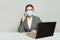 Happy smart business woman in protective medical mask with phone and laptop working in office