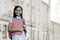 Happy smart kid wear glasses back to school carrying backpack and books at education building outdoors vintage filter