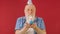 Happy and smile 70-year-old lonely elderly man with festive cone hat on his head celebrates his birthday, makes wish and