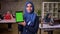 Happy smile of arabian woman who is showing green screen on her tablet and standing in modern office, arab women on