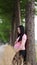 Happy smile Asian Chinese pregnant woman in yoga dress lean on tree in forest nature outdoor enjoy peaceful time live relaxed life