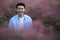 Happy smile Asian young man surround by purple hairawn muhly grass