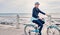 Happy, smile and cycling with old woman at beach for fitness, peace and travel with blue sky mockup. Relax, workout and