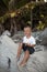 Happy smile european blond baby boy have rest and sit on white sand beach