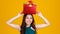 Happy smile face cute Asian girl with dark hair holding gift box over head  with delightful and excited, studio shot on yellow