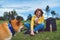 Happy smile girl holding in hands cup drink playing with red japanese dog shiba inu on green grass in outdoors nature park