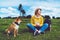 Happy smile girl holding in hands cup drink, red japanese dog shiba inu on green grass in outdoors nature park, beautiful young