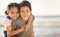 Happy, smile and portrait of siblings at the beach hugging and playing while on summer vacation. Happiness, ocean and