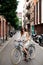 Happy smile young female traveler with bicycle and paper map in city center of Barcelona. Traveling in Spain