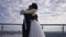 Happy smiling African American bride hugging groom standing on bridge outdoors. Camera moves around loving affectionate