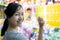 Happy smiling asian child girl holding a dart,looking at camera,  having fun, female teen playing the dart game with balloons for