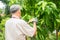 A happy and smiling Asian old elderly man is pruning twigs and flowers for a hobby after retirement in a home. Concept of a happy