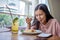 Happy smiling asian woman eating Italian pasta with lemonade in restaurants