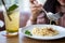 Happy smiling asian woman eating Italian pasta with lemonade in restaurants . close up