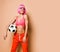 Happy smiling athletic woman with pink hair in sportswear posing with soccer ball on background with free copy space