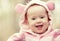 Happy smiling baby girl in pink hood with ears