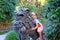 Happy smiling baby girl riding a statue of mythological lion in Royal Botanical Garden in Sydney, Australia