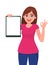 Happy smiling beautiful young woman holding / showing a blank clipboard and gesture hand okay / OK sign.