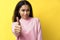 Happy smiling black woman showing thumbs up on yellow background. Focus on hand