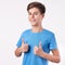 Happy smiling boy in blue t-shirt showing thumbs up in like or approval gesture giving positive feedback.