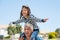 Happy smiling boy flying on shoulder of his grandfather