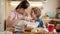 Happy smiling boy kissing his mother while making biscuit dough at home. Children cooking with parents, little chef