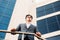 Happy smiling businessman wearing suit near office successful employer to make a deal while standing near skyscraper office