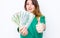 Happy smiling businesswoman wearing in green jacket with thumbs up gesture and money. Closeup portrait super happy excited success