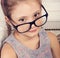 Happy smiling calm kid girl in eyeglasses looking. Closeup studio portrait