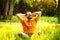 A happy smiling carefree man is sitting on green grass and folding arms behind head at sunny summer day at park background.