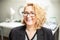 Happy smiling caucasian business woman in a black suit. Office interior as background