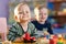 Happy smiling caucasian kids are playing with educational toys in nursery