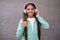 Happy smiling child enjoys listens to music in headphones. kid listen song outdoor. walking with favorite tune