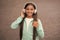 happy smiling child enjoys listens to music in headphones. kid listen song outdoor. walking with favorite tune